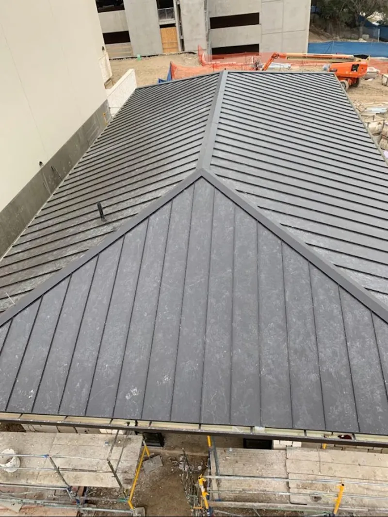 Commercial metal roof construction with crane equipment in Cleburne